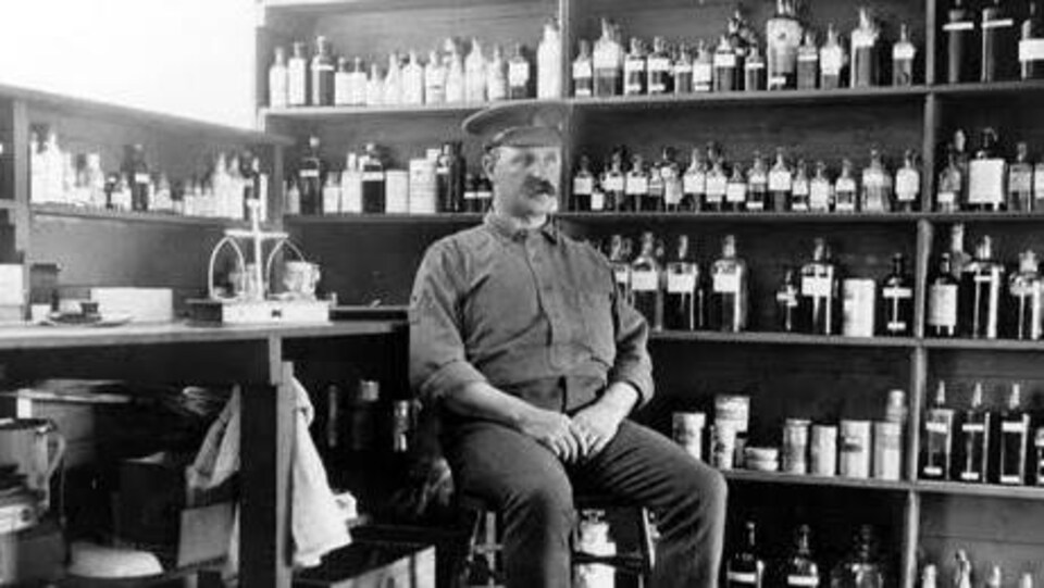 Un soldat assis dans une pièce remplie de bouteilles d'alcool.