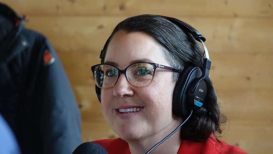 Une femme portant des écouteurs en pleine entrevue radio.
