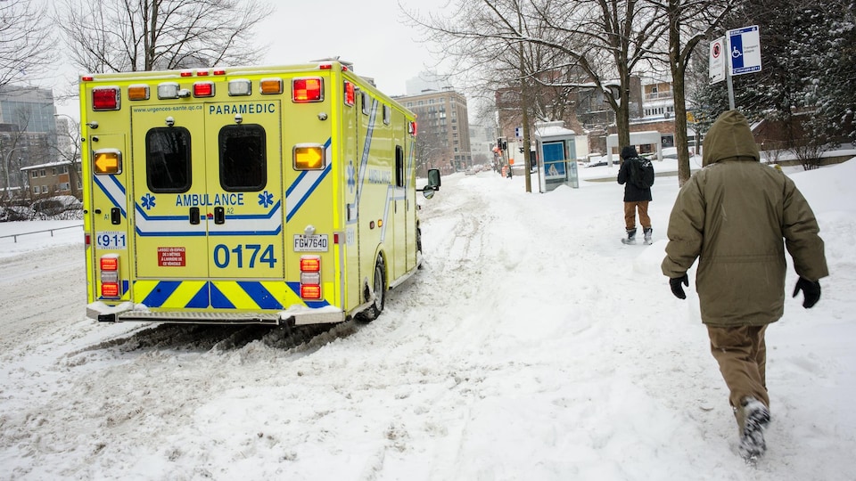 Une ambulance sur le bord d'une rue enneigée de Montréal.
