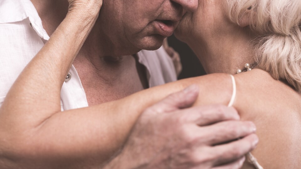 Un homme et une femme âgés s'enlacent.