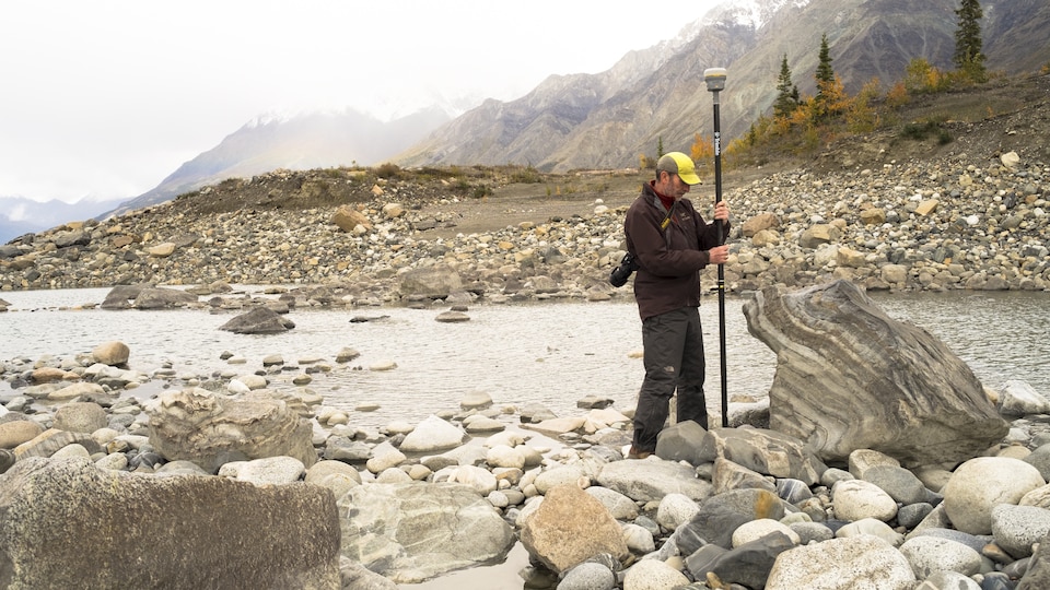Un chercheur mesure le niveau soudain très bas de la grande rivière Slims, affluent important du fleuve Yukon. 
