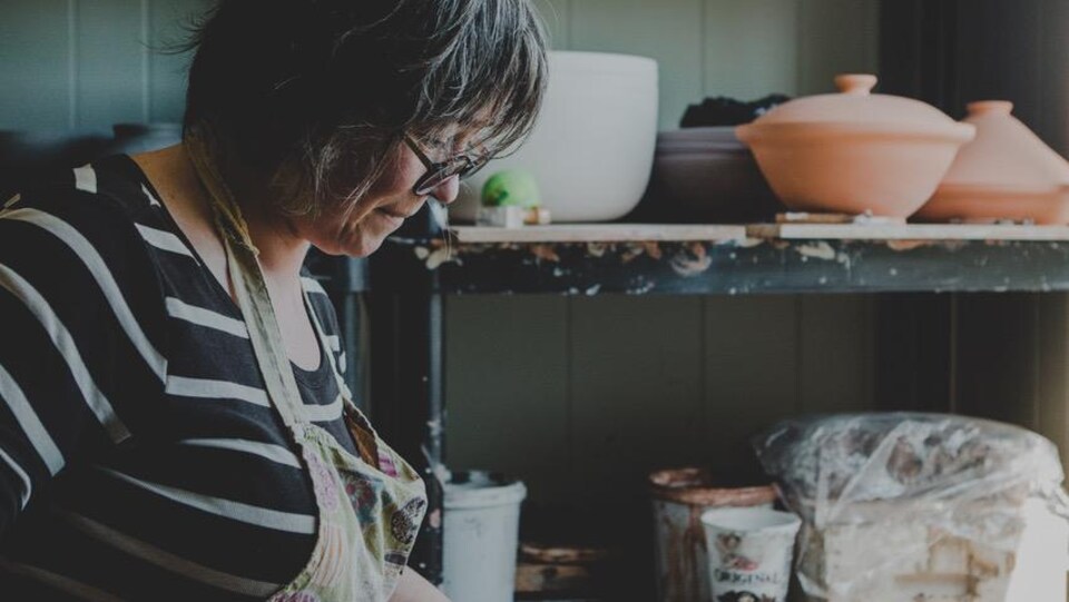 Annie-Cécile Tremblay, artiste céramiste aux Îles, manipulant la ceramique