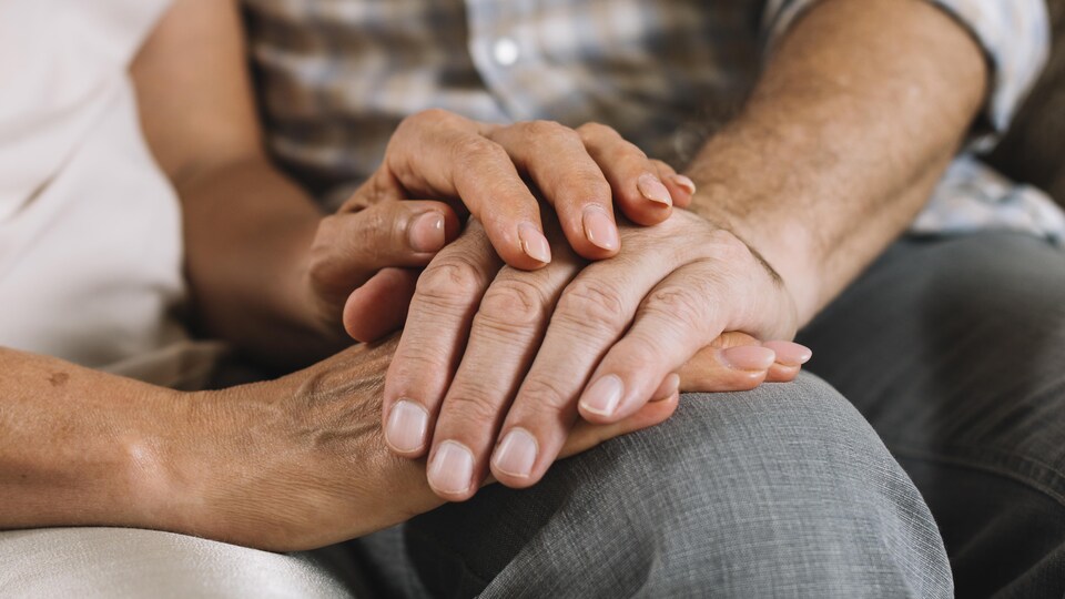 Les mains d'une femme tiennent les mains d'un homme.