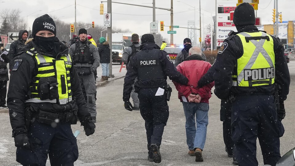 Des policiers arrêtent une personne.