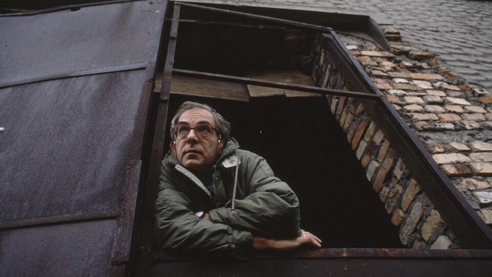 Le cinéaste Krzysztof Kieslowski en 1990 pose sur le rebord d'une fenêtre.