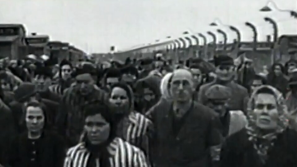 Image d'époque en noir et blanc de prisonniers dans un camp de concentration non identifié. 