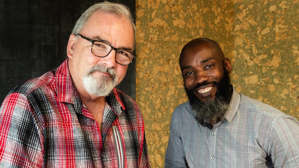 Les deux hommes posent en souriant.