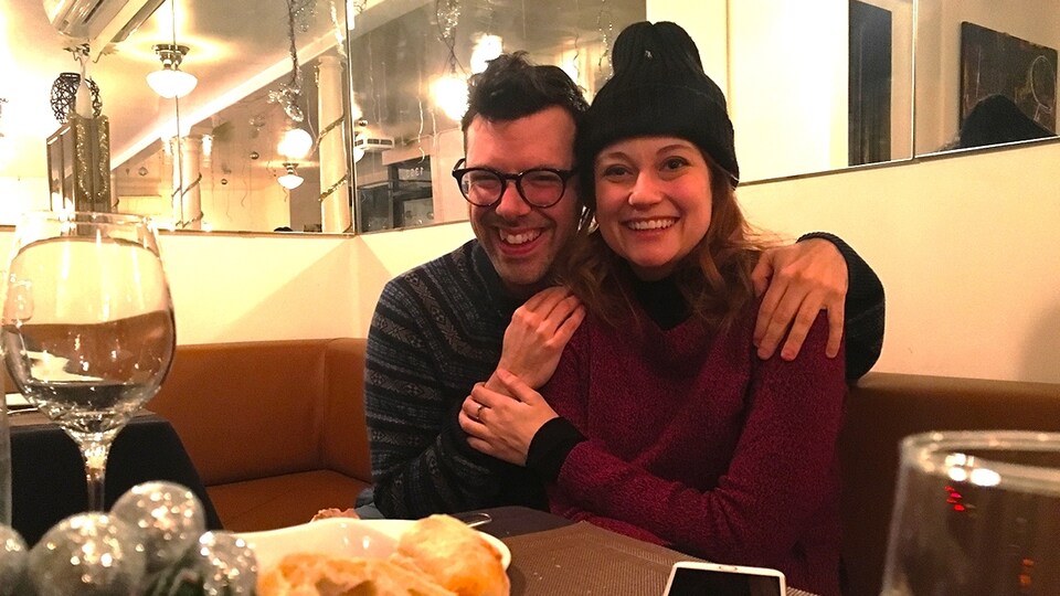 L'écrivain Simon Boulerice et l'humoriste Katherine Levac, enlacés et souriants, à la table d'un restaurant.