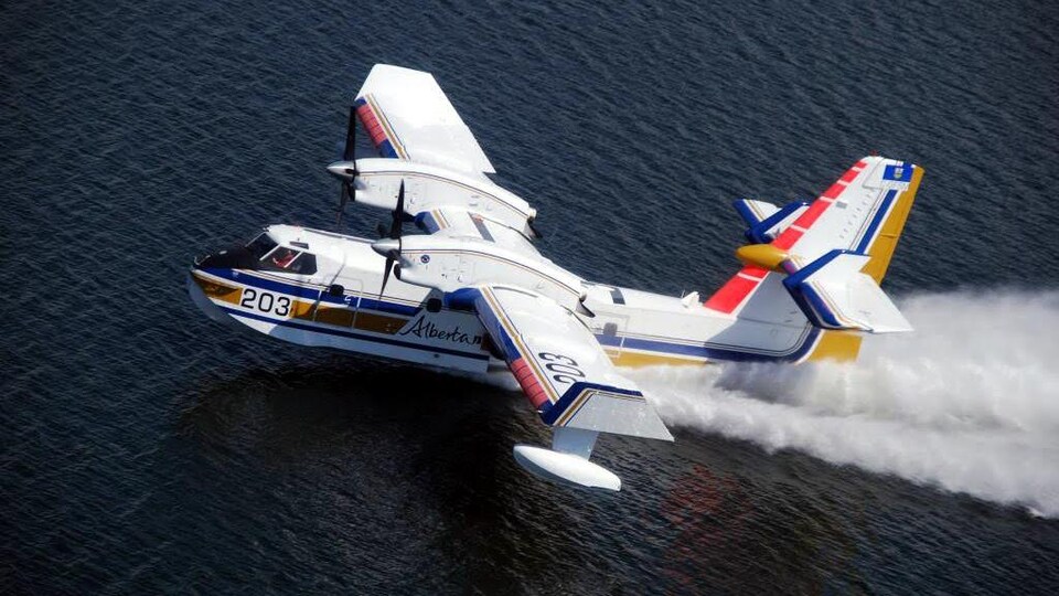 Un avion citerne vole au-dessus d'un lac.