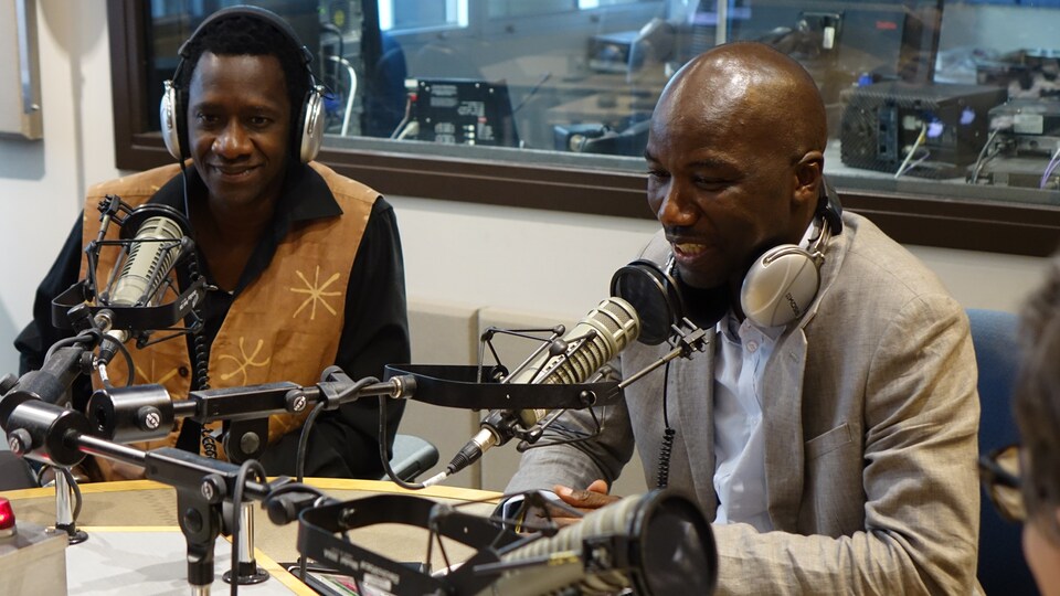 Photo de deux hommes en entrevue radio.