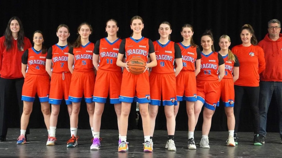 Une équipe de basketball féminin alignée sur une scène .