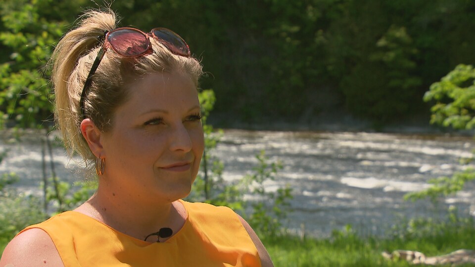 Sandra Demontigny lors d'une entrevue à l'extérieur avec une rivière en arrière-plan.