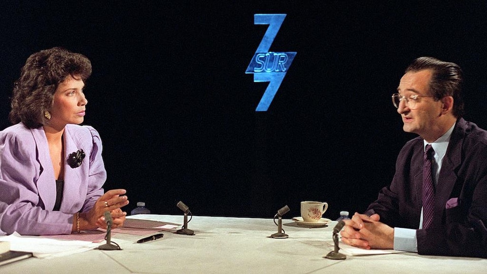 Les deux personnes discutent sur un plateau de télévision.