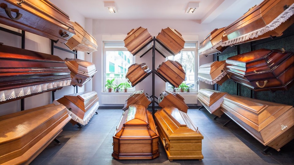 Une vingtaine de cercueils en bois exposés pour la vente. 