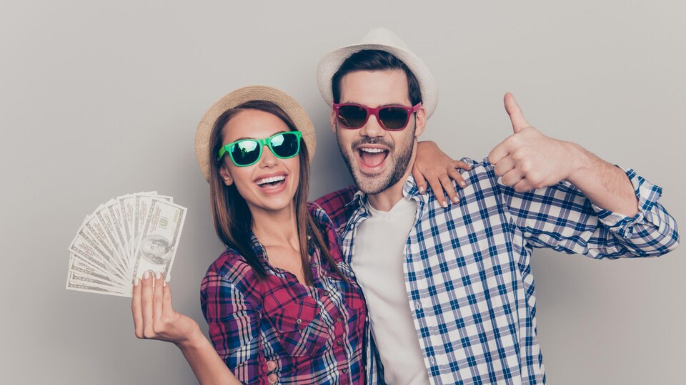 Une jeune femme et un jeune homme affublés de verres fumés montrent fièrement une liasse de billets de banque.