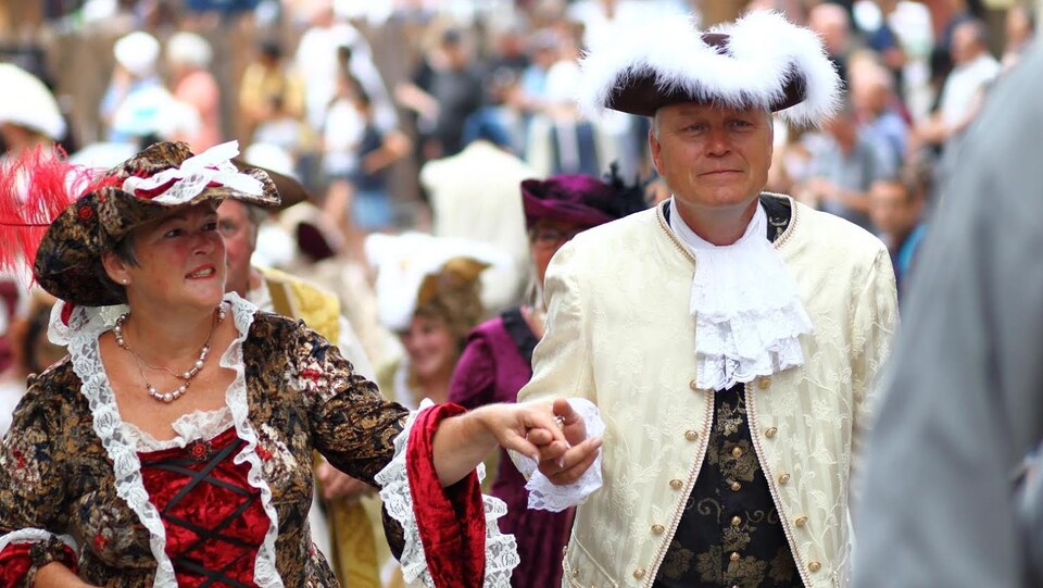 Un homme et une femme participent au défilé des Fêtes de la Nouvelle-France 2018.