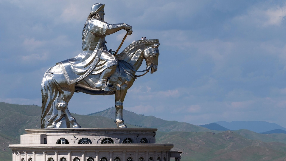 Une statue argentée de Genghis Khan sur un cheval.