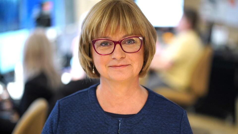 La sénatrice Julie Miville-Dechêne sourit lorsqu'elle se fait prendre en photo dans un studio de Radio-Canada.