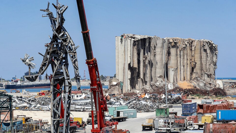 Une sculpture immense faite de débris de l'explosion dans le port de Beyrouth représente une personne debout qui tient un oiseau sur le point de s'envoler dans sa main.