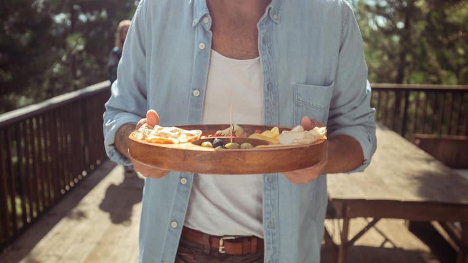 Un homme tient un plateau entre ses mains.