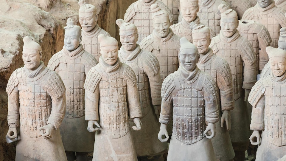 Vue sur une quinzaine de soldats de l'armée de terre cuite construite pour le tombeau de l'empereur chinois Qin Shi Huang.