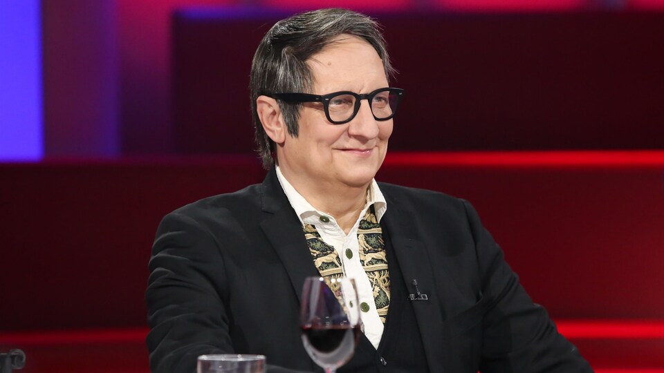 Il est assis sur le plateau de l'émission Tout le monde en parle.