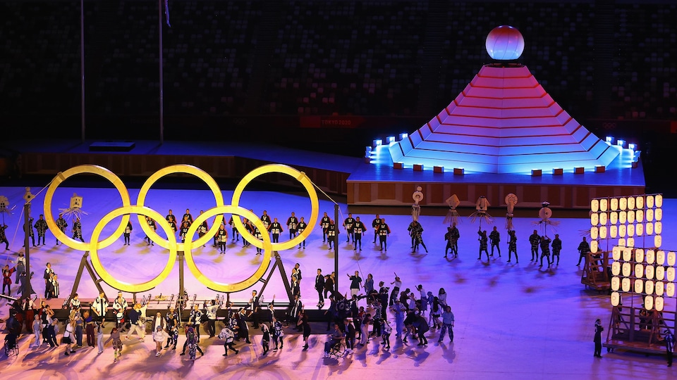 Les anneaux olympiques sont illuminés au centre du stade.