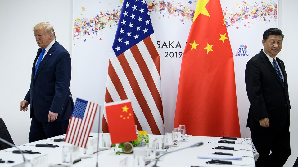 Donald Trump et Xi Jinping dans une salle de réunion avec des drapeaux américains et chinois.