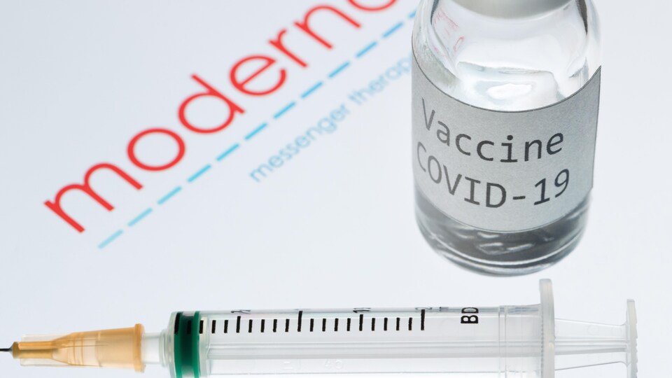 Une seringue et un flacon portant l'inscription « Vaccine COVID-19 » à côté du logo de la société de biotechnologie Moderna.