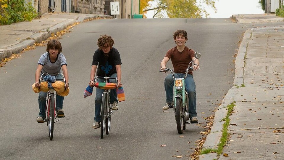 Trois garçon font du vélo.