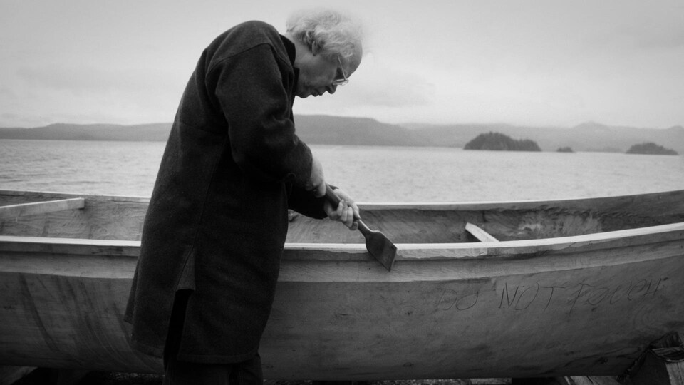 Bill Reid sculptant le canoë Loo Taas à Skidegate, 1984.