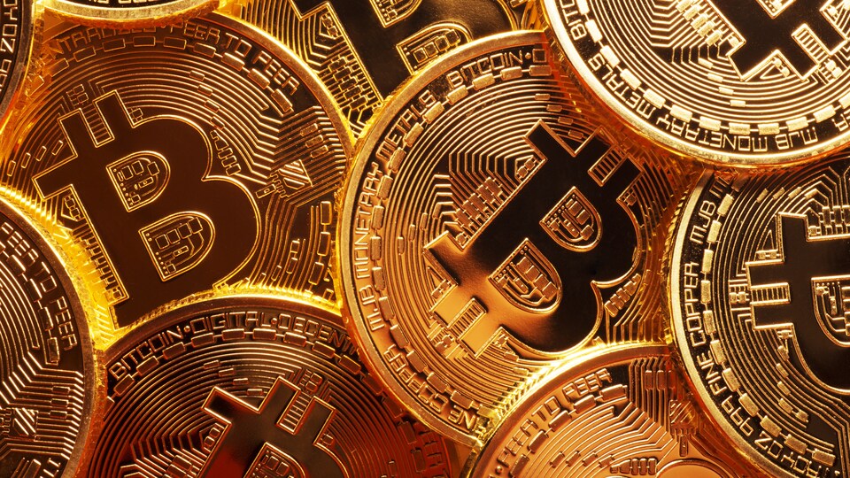 Une gros plan sur des pièces de monnaie dorées arborant le symbole de bitcoin.