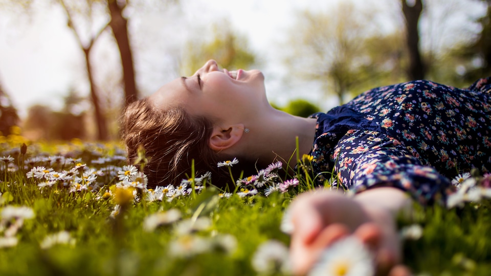 Une jeune femme couchée dans l'herbe