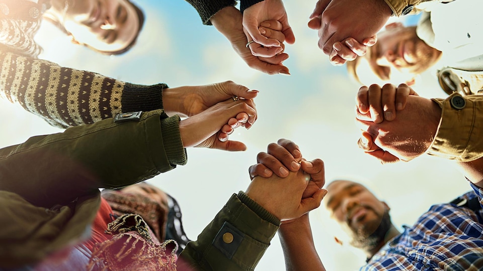 Un groupe d'amis se tiennent par la main le temps d'une prière.