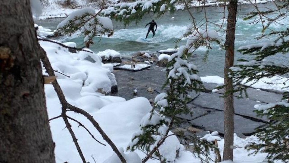 Surfeur sur rivière l'hiver.