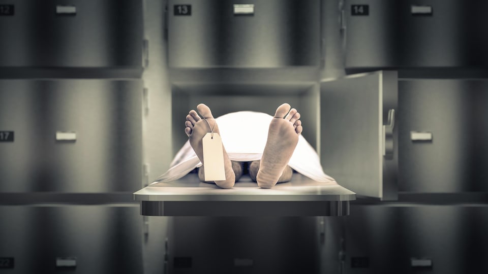 Les pieds d'un cadavre qui est étendu dans une morgue.