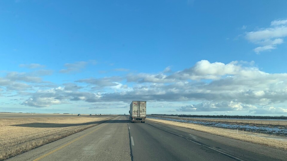 Un semi-remorque sur une autoroute au milieu des Prairies.