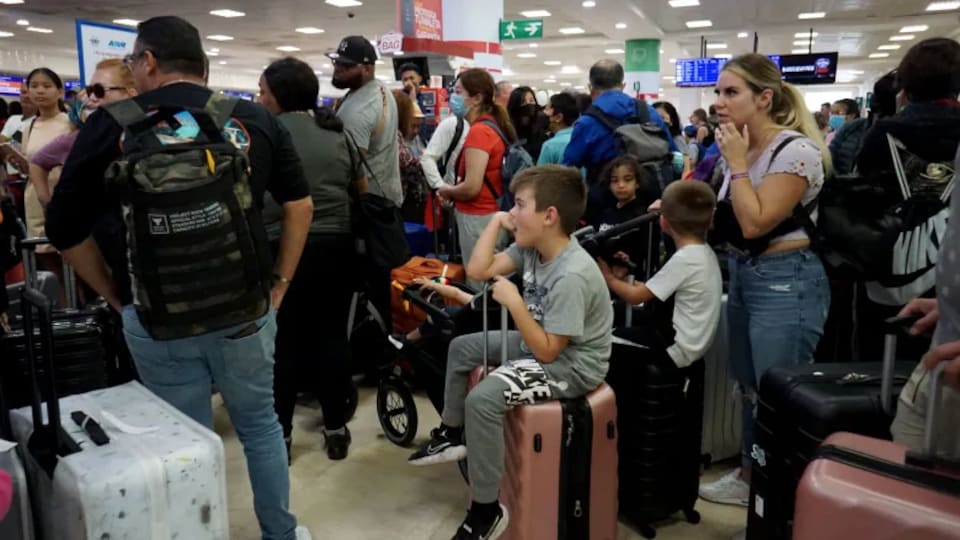 Des gens font la queue dans un aéroport.