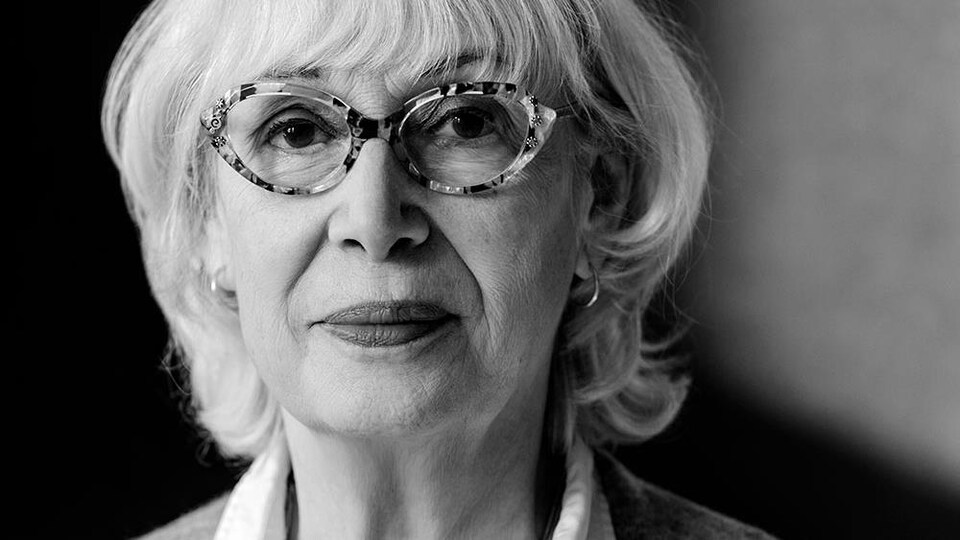 Elle sourit à la photographe. 