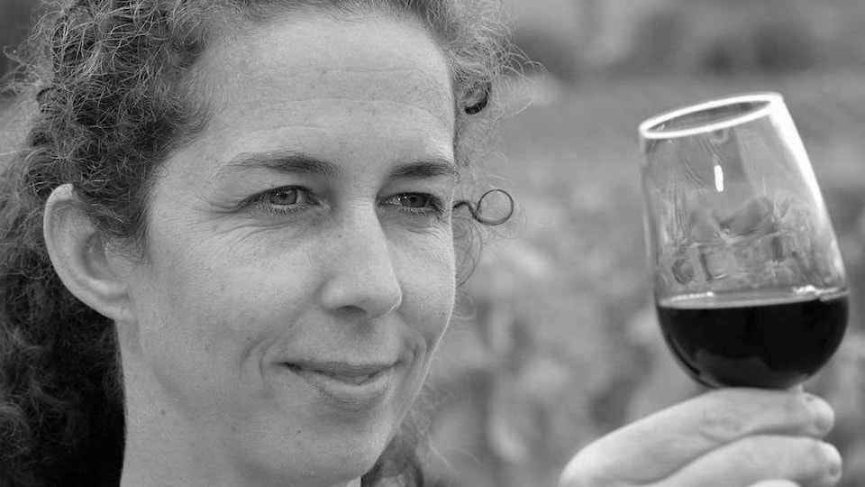 Caroline Schaller regarde un verre de vin rouge.