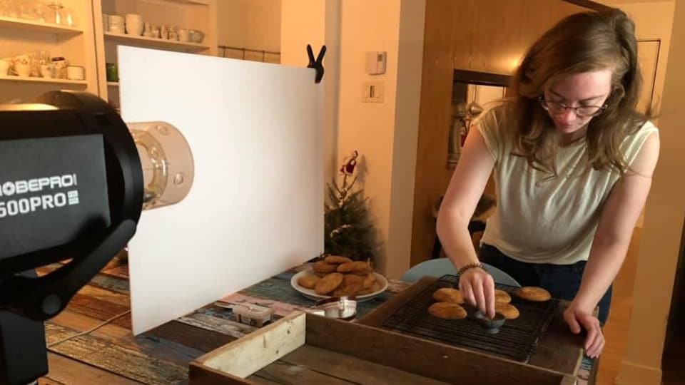 La photographe Catherine Côté, dans son atelier, s'affairant à composer une mise en place culinaire.