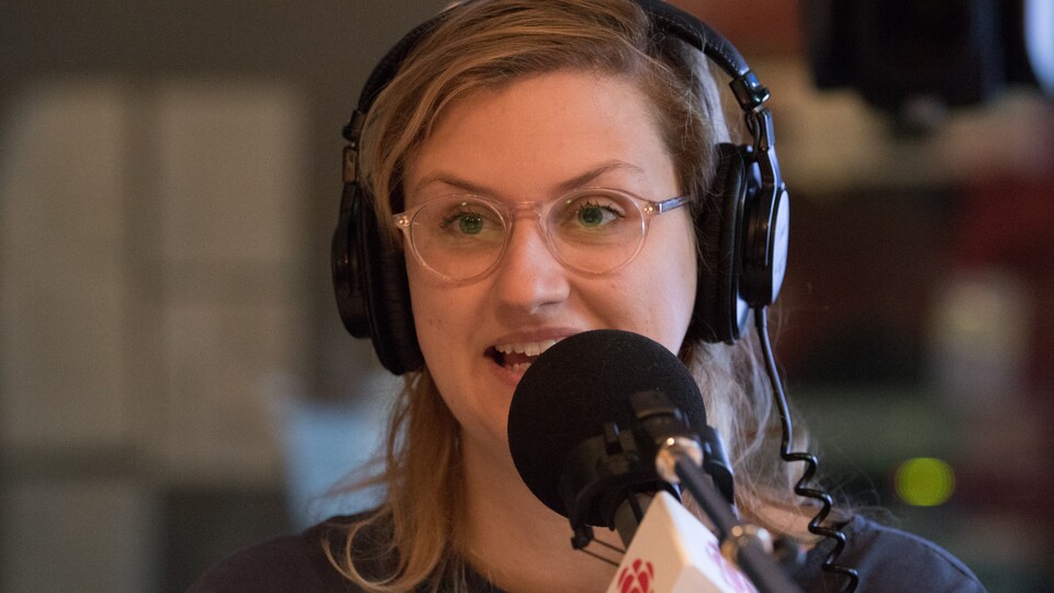 A woman wears headphones during an interview in a recording studio. 