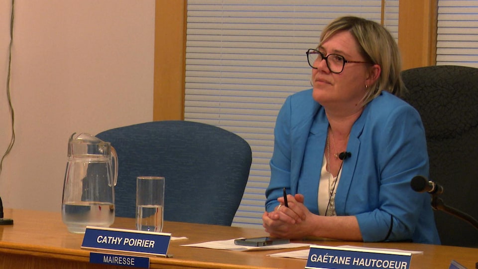 Cathy Poirier est assise à sa place et écoute les citoyens dans la salle du conseil municipal de Percé.