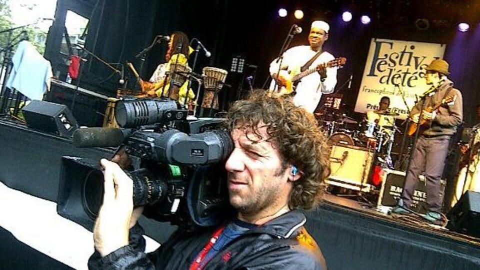 Daniel Beauparlant, caméra à l'épaule, devant la scène extérieure du Festival d'été de Vancouver.