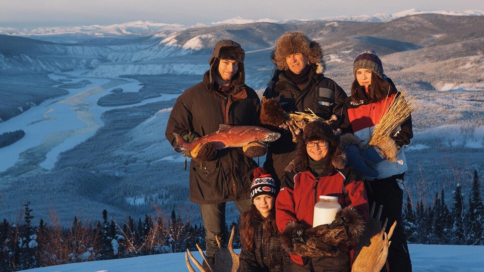 Les 5 membres 'dune famille posent en haut d'une montagne au Yukon.