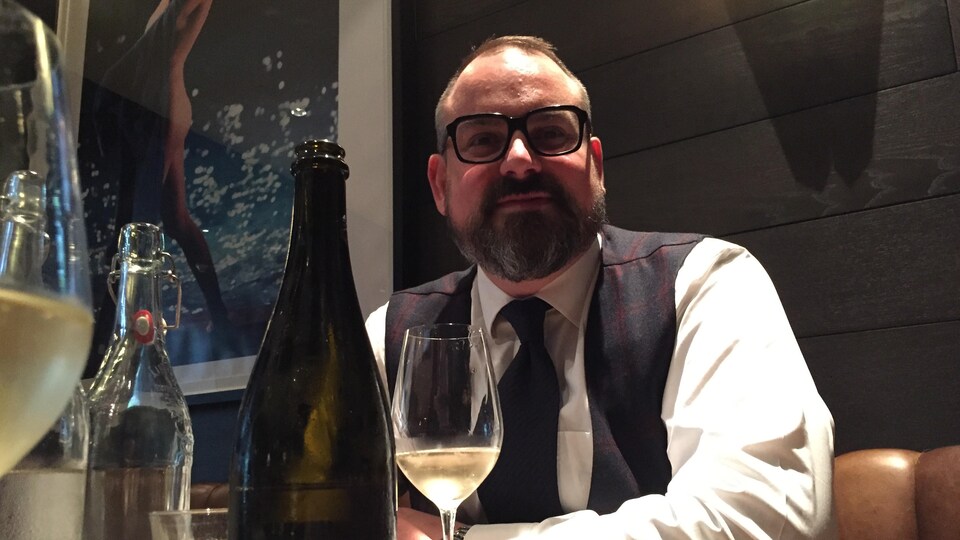 un homme barbu boit du champagne