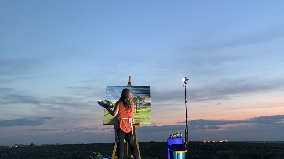 une femme peint de le ciel dans un champ