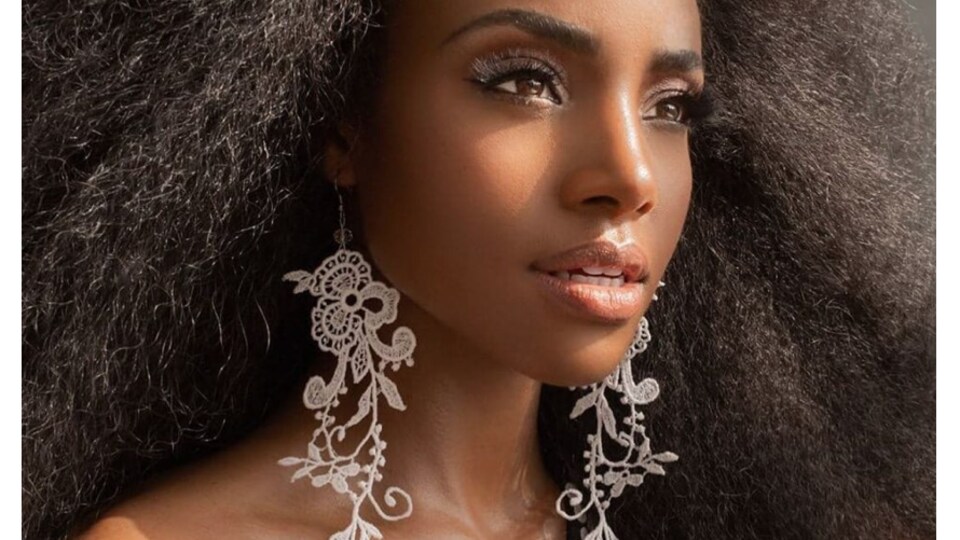 une jeune femme porte de longues boucles d'oreilles