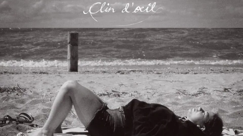 Une femme couchée sur le sable, sur une plage.