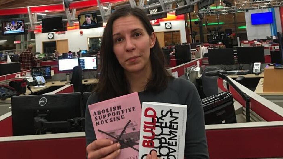 Cécile Revaux est dans une salle de nouvelles, et elle tient deux publications qui ont pour sujet, le logement.